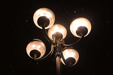Winter alley in park with benches and lanterns in frosty weather. Snow lies on everything and on trees, on lampposts and on benches.の写真素材