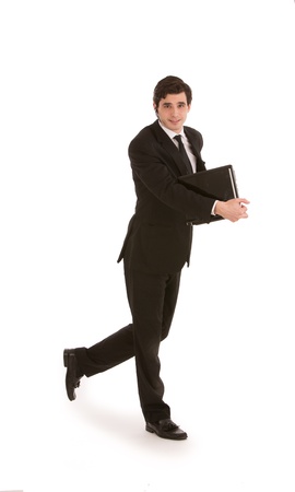 Attractive young businessman in a suit walking with a folder in his hand, full length mid stride studio portrait on whiteの写真素材