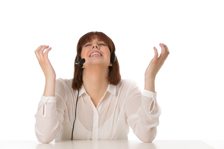 Frustrated call centre operator praying for help in dealing with a client raising her hands in the air with a look of annoyance, on whiteの写真素材