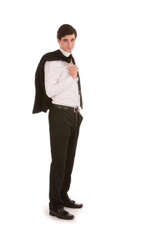 Handsome young businessman with his jacket over his shoulder standing sideways looking at the camera isolated on whiteの写真素材