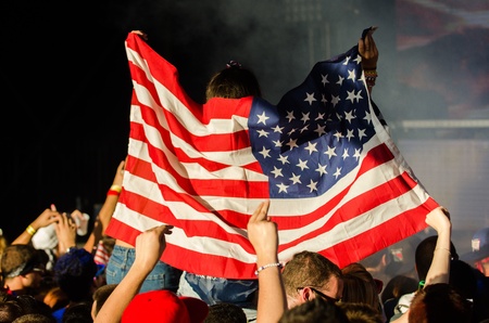 Photo taken as an EDM Concert Attendee Raises American Flagの写真素材