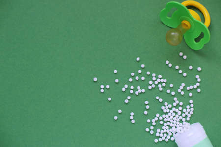 Homeopathic globules and with a plastic jar on a yellow background. Alternative Homeopathy medicine...