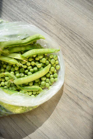 fresh peeled green peas are in a bag on the table. stubs of green peas. peeled fresh green peas.food for vegetarians.の写真素材