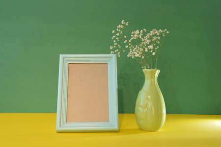 blue blank photo frame on green background with vase and flower, mockup, Space for text, Copyspaceの写真素材