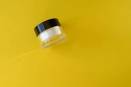 small white jar with black lid on a colored background mockup, Space for text, Copyspace. cosmetology. face cream in a jar with a closed lid.の写真素材