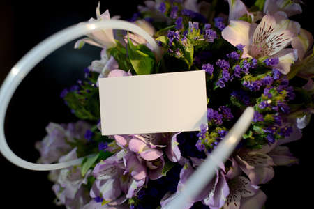 Close-up basket with alstrameria flowers and business card with place for text. a bouquet of flowers for the catalog of the online store. Floral shop concept. Flowers delivery. copy spaceの写真素材