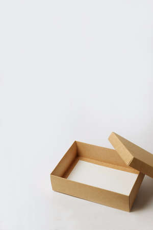 open Cardboard craft box with cover on white background top view. The concept of delivery, mail, destinations, the quarantine period is relevant. Copy space.の写真素材