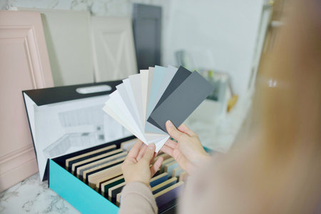 Banner Home improvement concept. young girl designer opens a drawer of a kitchen cabinet in a shop salonの写真素材