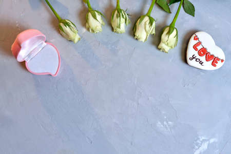 Heart box with flowers and gift on grey