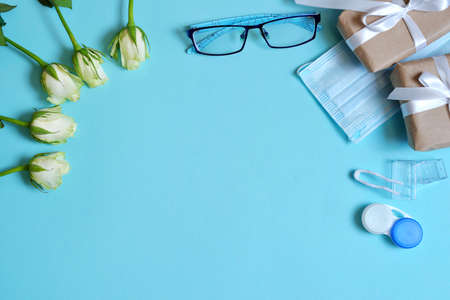 glasses and lenses for correcting vision on a colored background, top view. Ophthalmologist Accessories. top view. mockup. white rose flowers for the holiday.の写真素材