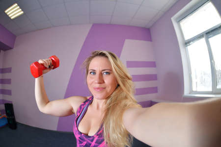 a young blonde girl the trainer of a dance fitness wears a black mask during a pandemic leads training sessions in a port clubの写真素材