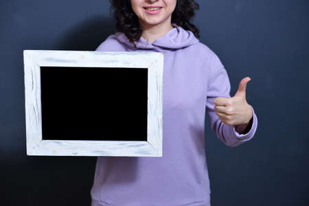 young girl holding a frame with metosm for the test. concept of sales and black friday after...
