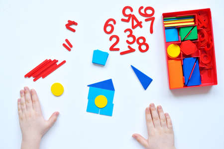 The child learns Number line and geometric shapes. The preschooler works with Montessori material. Educational logic toys for kid's. Children's hands close-up. Montessori Games for Child Development.の写真素材