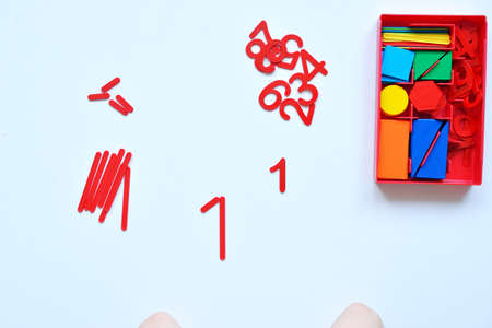 The child learns Number line and geometric shapes. The preschooler works with Montessori material. Educational logic toys for kids. Childrens hands close-up. Montessori Games for Child Developmentの写真素材