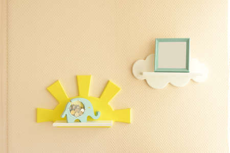 Stylish and modern Interior design. Home for the child room. close-up of a man screwing a frame in the form of a yellow sun to the wall with a screwdriver. home improvement and comfort.の写真素材