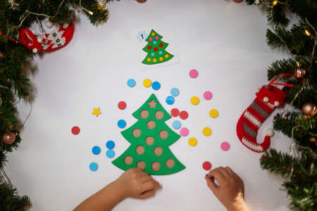 happy girl puts on New Year's glasses with a tree and rejoices at Christmas. merry christmas conceptの写真素材