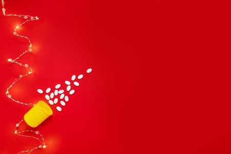 medical layout on red background with beautiful garland of christmas tree of pills concept of merry christmas for doctors and medical clinicsの写真素材