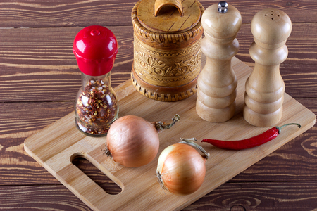 Spice, pepper, onion for cooking on cutting board.の写真素材