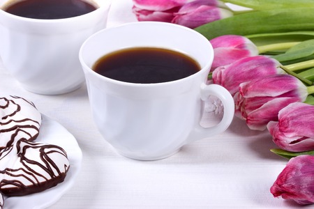 Breakfast with coffee,fresh tulips and cake on wooden table.の写真素材