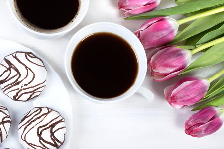 Breakfast with coffee,fresh tulips and cake on wooden table.の写真素材