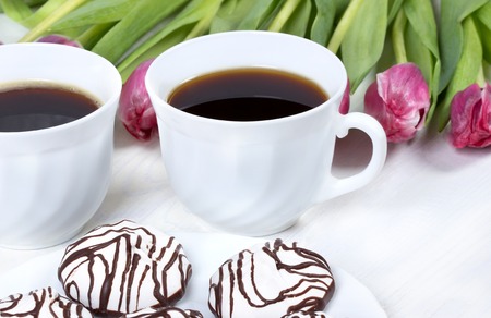 Breakfast with coffee,fresh tulips and cake on wooden table.の写真素材