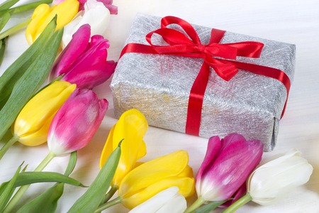 Fresh pink tulip flowers in gift box on wooden table.の写真素材