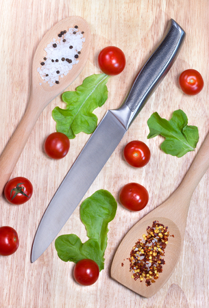 Fresh vegetables - tomato cherry and knife on wooden board. Top view. Healthy food concept.の写真素材