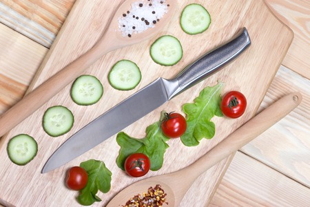 Sliced cucumber,cherry tomatoes, spice on wooden cutting board.Healthy food concept.の写真素材