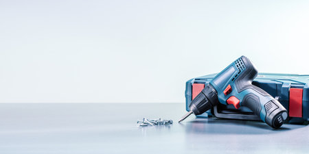 electric screwdriver with screws on gray surface. banner with copy space.の写真素材