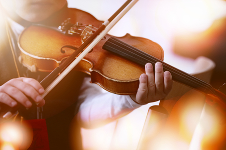 Child playing the violin in the roomの写真素材