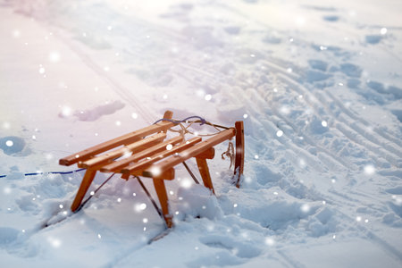Wooden sleds with snowflakes on the road in winterの写真素材