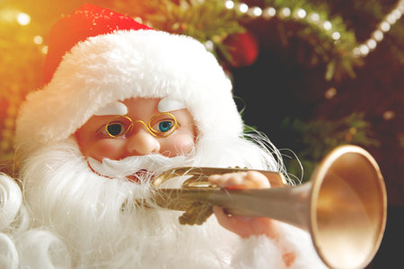 Santa Claus playing the trumpet near the Christmas tree. Christmas concept.の写真素材