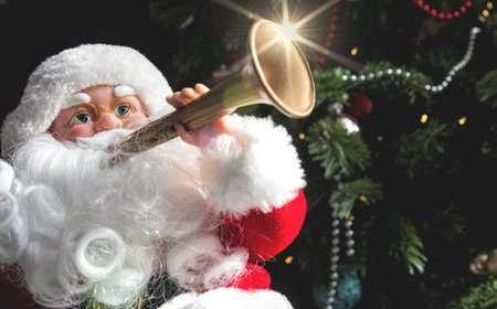 Santa Claus with a trumpet near the Christmas tree. Christmas and New Year.の写真素材