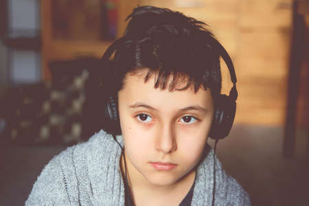 Teenage boy in headphones using digital tabletの写真素材