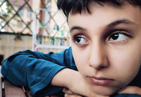 Close up Pensive Boy Leaning his Face on his Hands