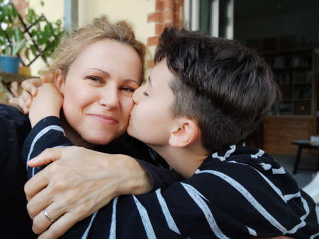Portrait of lovely mom and happy child enjoying spending funny time together. Mother kissing  Sohn