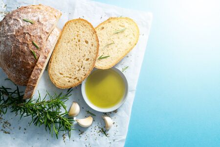 Slices of bread on papyrine with garlic, olive oil and rosmarine. Horizontal, flat lay, copy space....