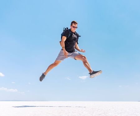 Traveling man jumping like a rock star at Tuz salt lake, Turkey. Rock and roll style concept.の写真素材
