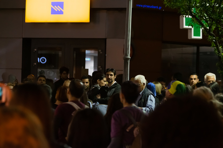 Kavala, Greece - May 10 2019: Crowded street near Piraeus bank during night festival in Kavala Greece with random guy looking at the camera.のeditorial素材