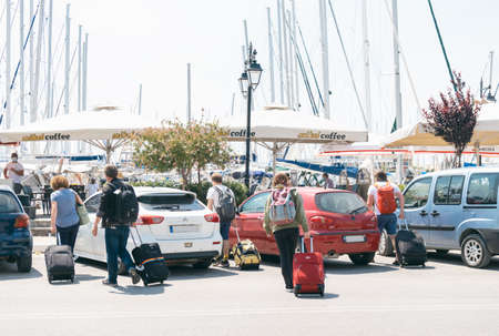 Tourists arrived at the Lefkada town, walking on the street with luggage.のeditorial素材