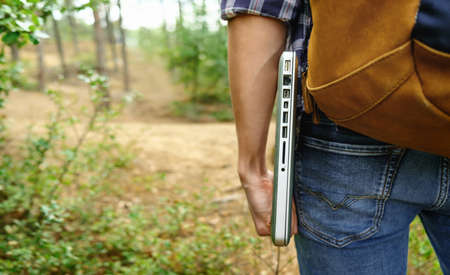 Young man holding laptop at the forestの写真素材