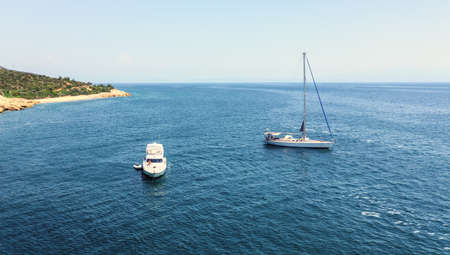 Aerial view of two anchoring yacht in open sea water. Sea travel and transportation concept
