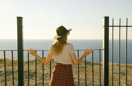 Girl traveler standing on the mountain top and looking at seaの写真素材