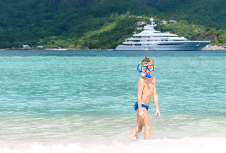 cute little boy wearing snorkel while standing on beachの写真素材