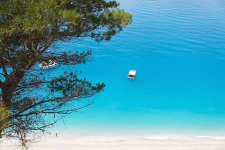 Top view of small fishing boat in aqua blue sea water.の写真素材