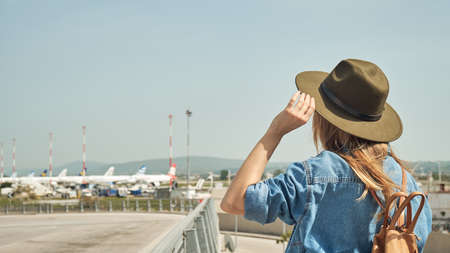 Girl in hat with backpack traveling in the airportの写真素材
