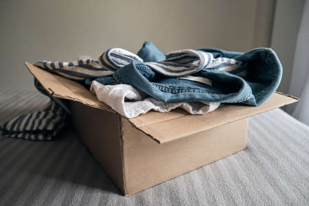 Cardboard box with pre owned clothes inside.の写真素材