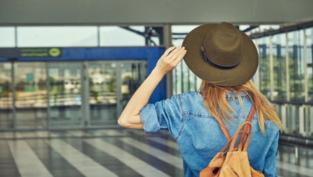 Girl in hat with backpack traveling in the airportの写真素材