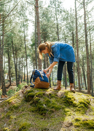 Young active woman with backpack at forest during sunny day.の写真素材