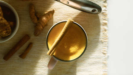 Cup of turmeric latte with cinnamonの写真素材